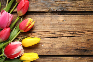 Beautiful spring tulips on wooden background, flat lay. Space for text