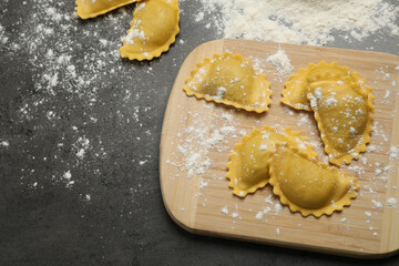 Flat lay composition with raw ravioli on grey table. Italian pasta
