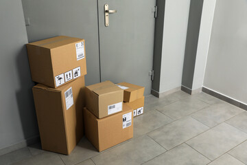 Cardboard boxes on floor near entrance. Parcel delivery service