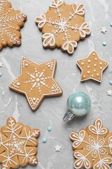 Tasty Christmas cookies and bauble on light grey marble table, flat lay