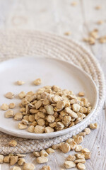 Plate of raw dry Grass pea close up on wooden table. Legumes known in Italy as Cicerchia
