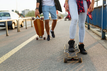 Portrait of happy teenager people having fun while driving a skateboard in city outdoors.