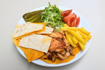 Turkish and Arabic Traditional Ramadan chicken doner kebab with tasty tomato sauce and rice or turkish pilav in white plate on wood table background. (Pilav ustu tavuk doner)