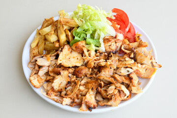 Turkish and Arabic Traditional Ramadan chicken doner kebab with tasty tomato sauce and rice or turkish pilav in white plate on wood table background. (Pilav ustu tavuk doner) - Powered by Adobe