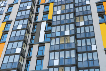 Balconies and windows of a multi-storey residential building. Abstract urban background.