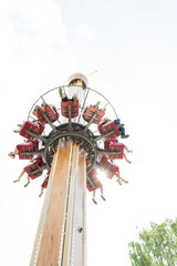 An attraction in the park, people ride on a carousel, a view from below on a sunny day