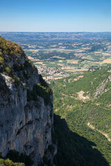 Fototapeta na wymiar Falaise du site de Combe Laval dans le Vercors et vue sur la plaine de la Drôme vers Saint Jean en Royans