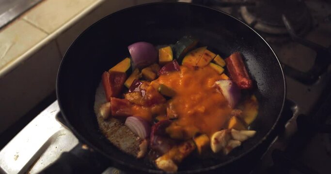 frying onion, tomato, chili and "zapallo loche" in a pan. Slow Motion 4k.