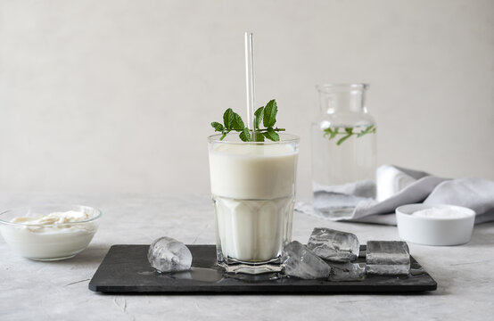 Ayran or Doogh is a popular refreshing Middle Eastern beverage made with yogurt, water and salt. Concrete background