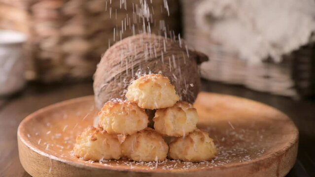 Coconut cookies. Homemade gluten free pastry with coconut. Small round sweets on a wooden table. High quality photo. Coconut shavings and real coconut are pouring