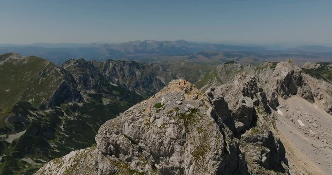 aerial view of bobotov kuk peak 2523  m high with tourists with blue lake on background