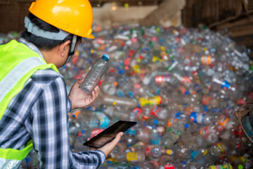 A recycling Analyst looking at plastic bottle ofr recycling waste To proceed to the next process. A...