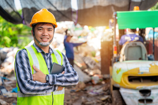 Portrait  of  Asian  workers in recycling factory with a forklift on the background, engineers standing in recycling center. Recycle waste, Garbage recycle.