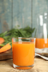 Glass of freshly made carrot juice on wooden table