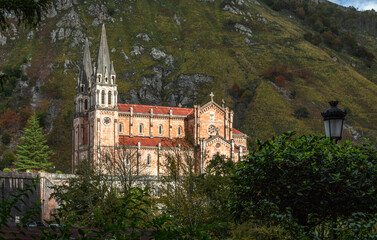 Fototapeta na wymiar Basílica de Santa María la Real de Covadonga. Low point view of this great monumental temple built from 1877 to 1901, with a neo-Romanesque style and is made of pinkish marble stone extracted from the