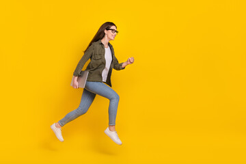 Fototapeta na wymiar Full size profile side photo of attractive office worker girl jumping up run to workplace isolated on yellow color background