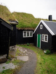 Fototapeta na wymiar Old town of capital city of Torshavn. A narrow cobblestone street and typical wooden houses in Torshavn on Streymoy Island. Faroe Islands, Denmark, Northern Europe