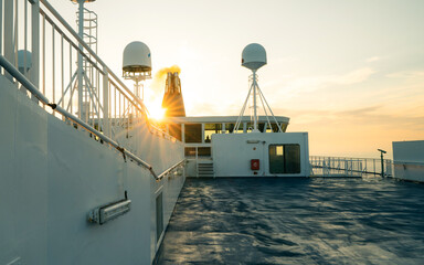 Beautiful sunset sky on ferry boat. Shipping sea car ferry radar system on boat mast, satellite...