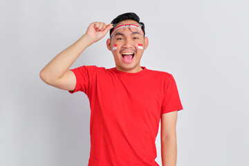 Shocked young Asian man celebrating Indonesian independence day take off glasses isolated on white background