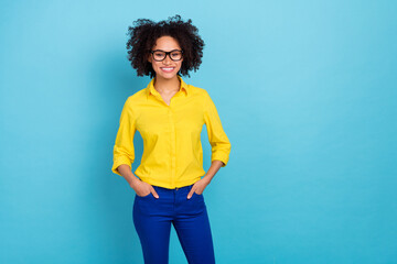 Photo of smart curly hairdo young lady wear yellow blouse eyewear isolated on blue color background