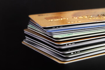 A stack of bank credit cards on dark background