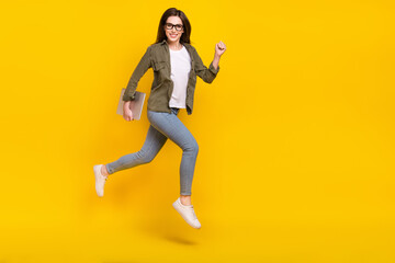 Fototapeta na wymiar Full body photo of good mood energetic young business lady running to work isolated on yellow color background