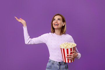 woman watching movie film, holding bucket of popcorn