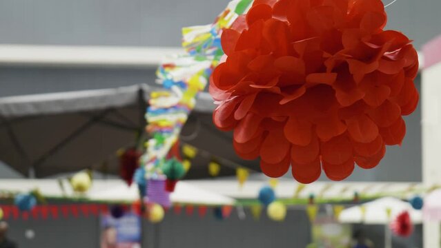 Colorful flags and red figure blowing in the wind - they are used for decoration at the S&atilde;o Jo&atilde;o and Santos Populares in Lisbon and Porto, Portugal. This one is called Manjerico (Ocimum minimum).