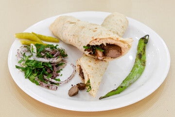 Turkish and Arabic Traditional Ramadan chicken doner kebab with tasty tomato sauce and rice or turkish pilav in white plate on wood table background. (Pilav ustu tavuk doner)