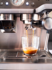 Professional coffee machine serving espresso in a glass cup