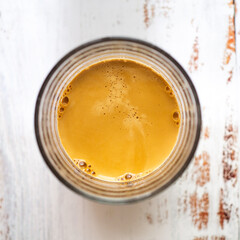 Top view of a glass cup with freshly brewed espresso coffee