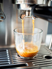 Professional coffee machine serving espresso in a glass cup