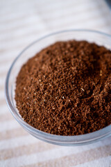 Close-up view of freshly ground coffee on a rustic white table