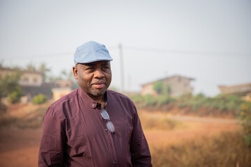 Portrait of a happy mature African gentleman wearing a flat cap outdoors.