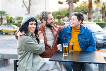 Group of happy friends drinking beer in outside cafeteria – young people having fun in outdoor rooftop bar restaurant – reunion at bar of friends 
