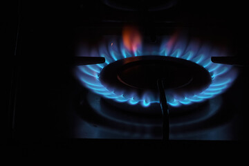 Burning gas, gas stove burner, hob in the kitchen. Blue gas flame. Selective focus.