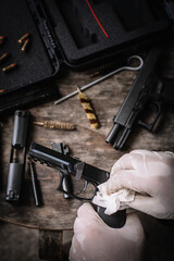 The gunsmith is sitting around cleaning the gun and disassembling and maintaining the pistol.