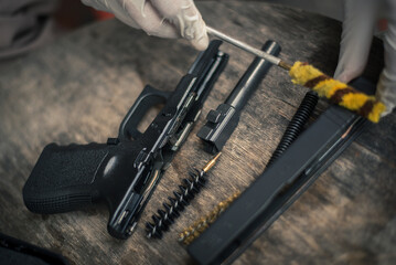 The gunsmith is sitting around cleaning the gun and disassembling and maintaining the pistol.