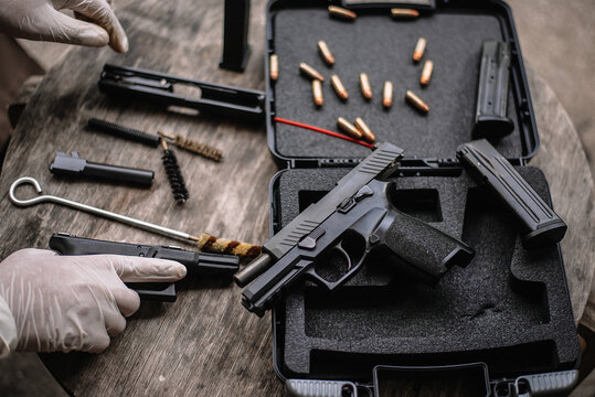 The gunsmith is sitting around cleaning the gun and disassembling and maintaining the pistol.