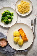 Homemade baked salmon served with popatoes, broccoli and sauerkraut