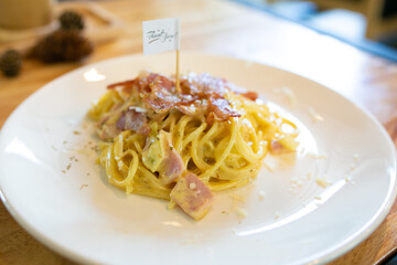 Spaghetti Carbonara with bacon and parmesan on wooden table. Italian food.	
