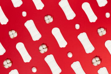 sanitary napkin and natural cotton lined up on red background