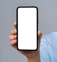 Mature woman hand holding smartphone with white screen isolated on white background. Modern phone with touch screen in woman hand. Close up. Mock up mobile app advertising