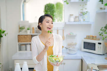 Healthy Smiling Girl with Bowl of Salad and Fork.