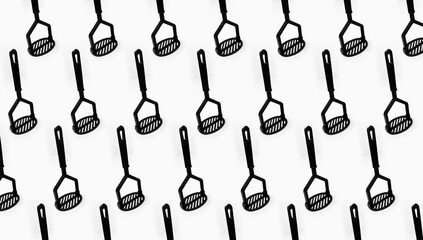 Pattern of black plastic potatoes masher on white background.