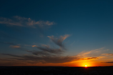 Beautiful landscape of sunset with dark colourful clouds. Natural background.