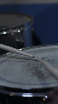 Closeup of drumsticks softly playing the drums