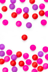 Abstract colored balls background. Red, pink taw toy scattered on isolated white background. Base for design nice backdrop, wallpaper, poster