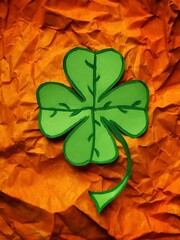 Four leaf clover on background from Apricot Crush crumpled craft paper with copy space and...