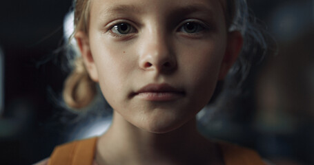 Closeup face frightened girl in dark hall. Schoolgirl standing school corridor.